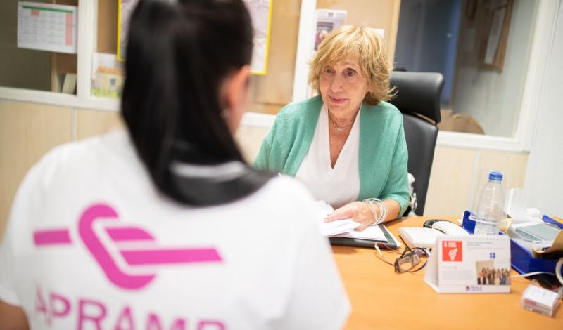 Imagen de una mujer superviviente de la trata siendo atendida por una profesional de APRAMP