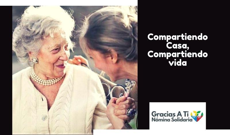 Una mujer mayor le da la mano con un gesto cariñoso a una mujer de mediana edad, ambas están contentas y sonrientes