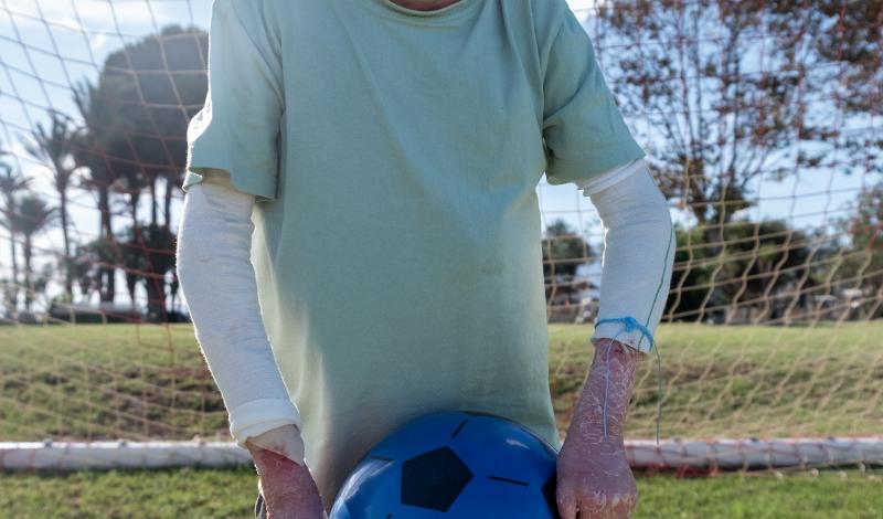 Foto de Leo en un campo de fútbol sosteniendo su balón.