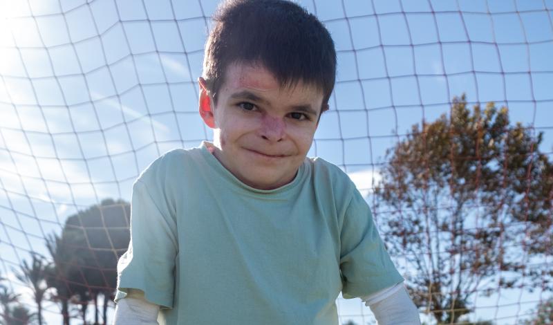 Foto de Leo en un campo de fútbol sosteniendo su balón.