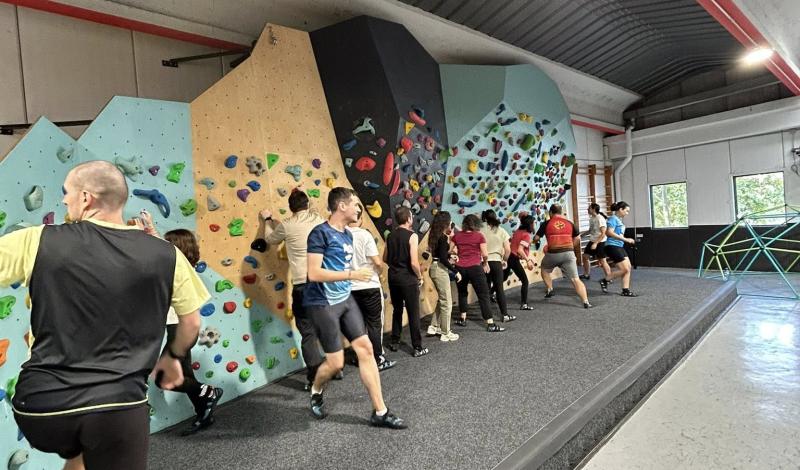 Rocódromo de escalada con jóvenes preparados para realizar la actividad