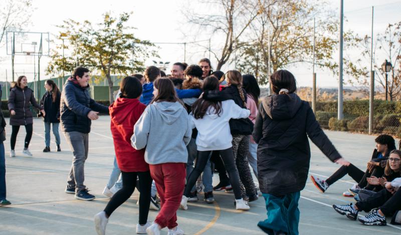 Grupo de jóvenes tutelados se abrazan en corro 