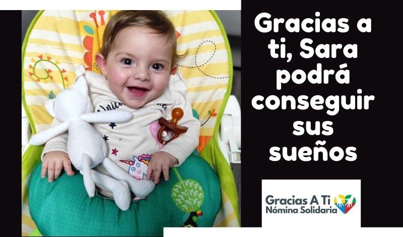 En la imagen aparece Sara. Un bebé de 9 meses con una amplia sonrisa y sentadita en la hamaca. 