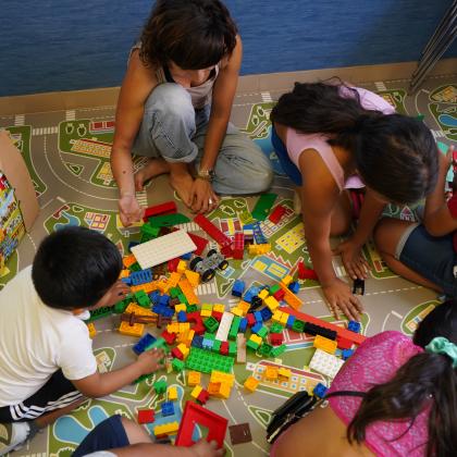 Un grupo de niños en situación de vulnerabilidad juegan en uno de nuestros centros junto a una monitora.