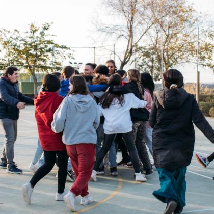 Grupo de jóvenes tutelados se abrazan en corro 