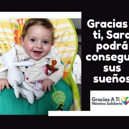 En la imagen aparece Sara. Un bebé de 9 meses con una amplia sonrisa y sentadita en la hamaca. 